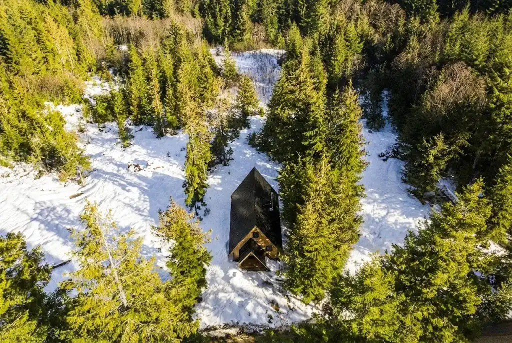 Interior detail of A Plus A-frame cabin with warm timber framing, woodstove, and industrial touches