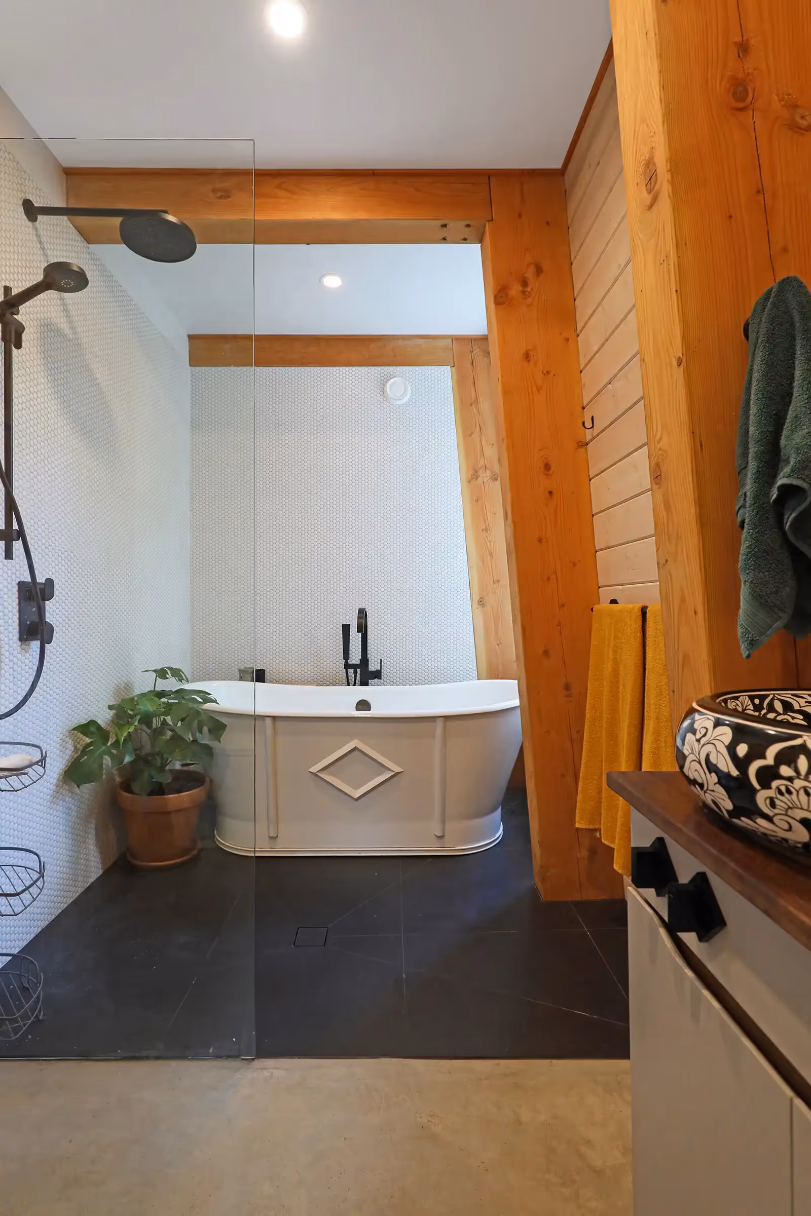 Bathroom with hexagon tiling and freestanding soaker tub in Forbidden Black mountain cabin