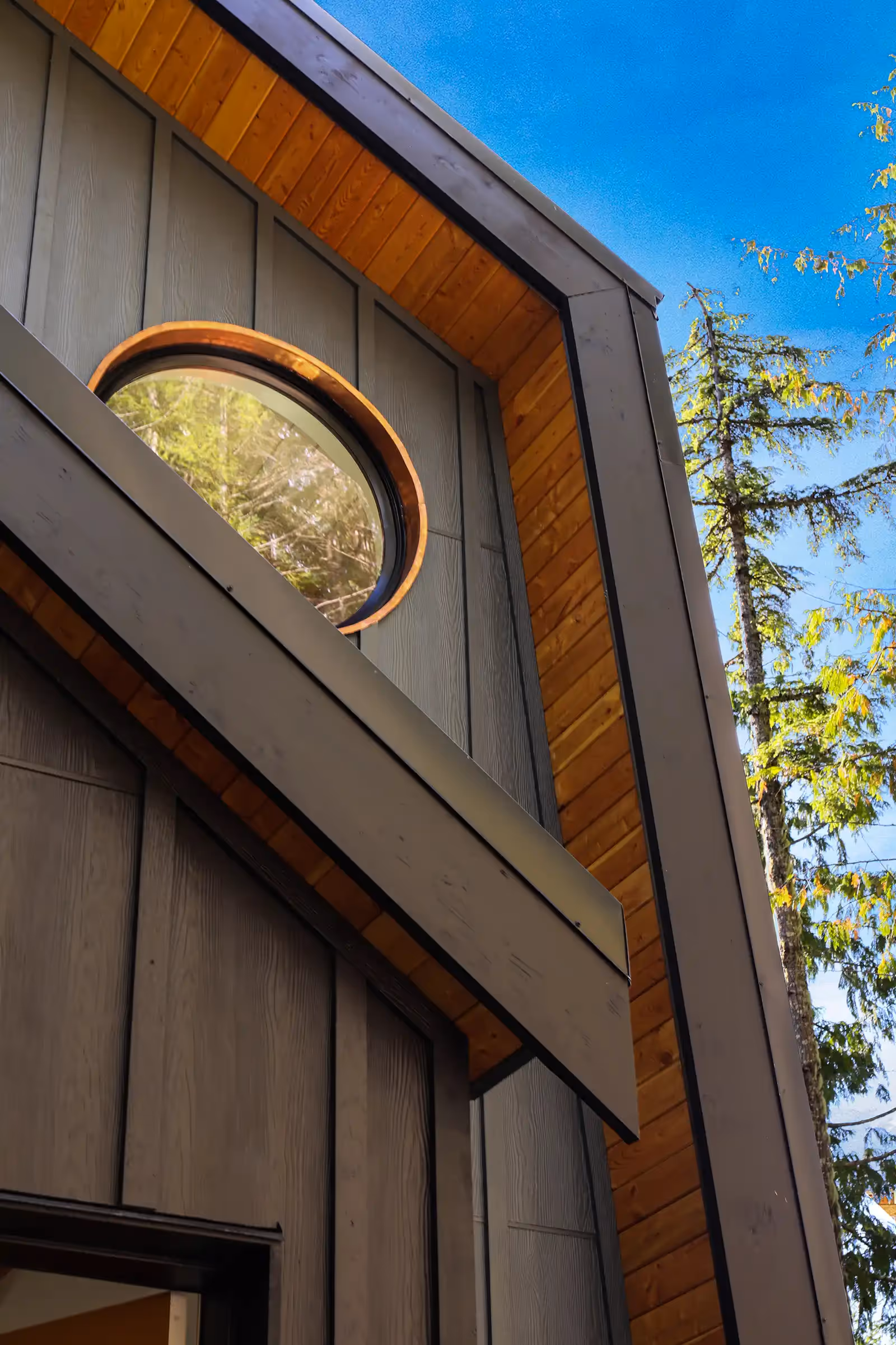 Dramatic exterior of Forbidden Black modified A-frame with dark cladding, bold angles, and warm wood accents