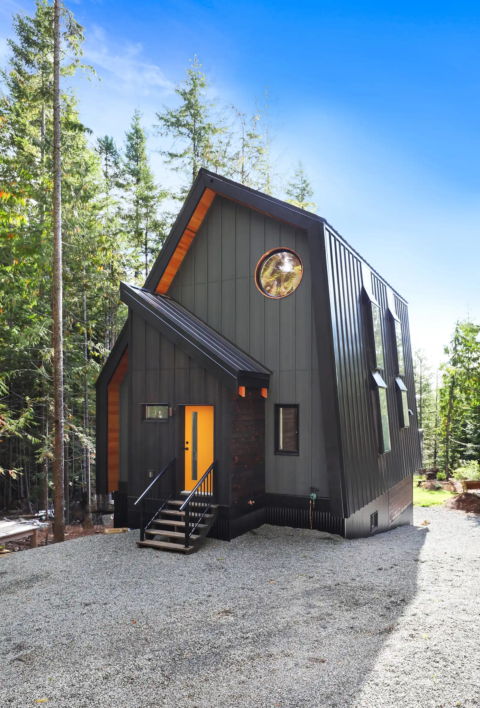 Exterior view of Forbidden Black A-frame surrounded by tall evergreens at Forbidden Plateau