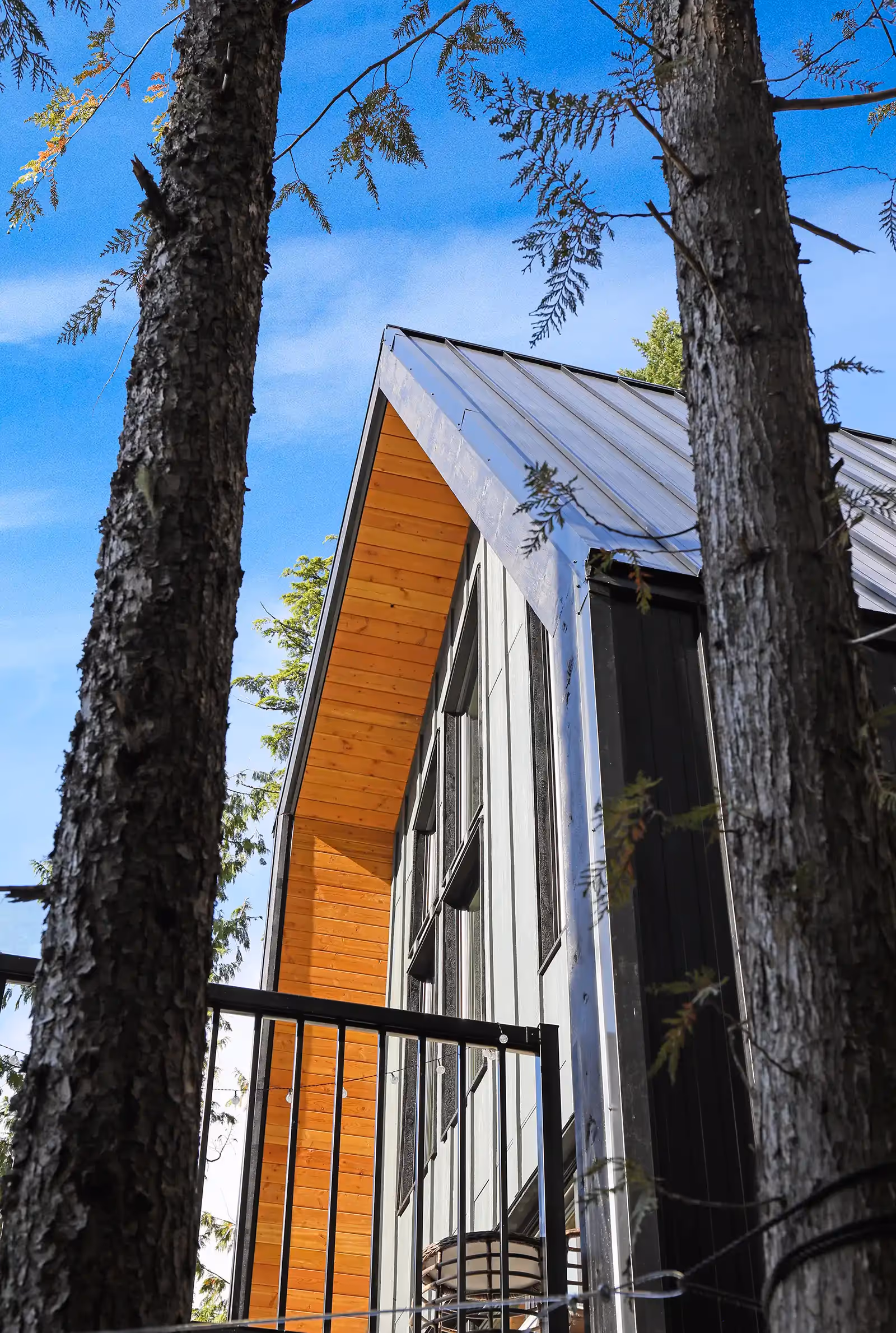 Front entry of Forbidden Black with vibrant orange door contrasting against all-black exterior