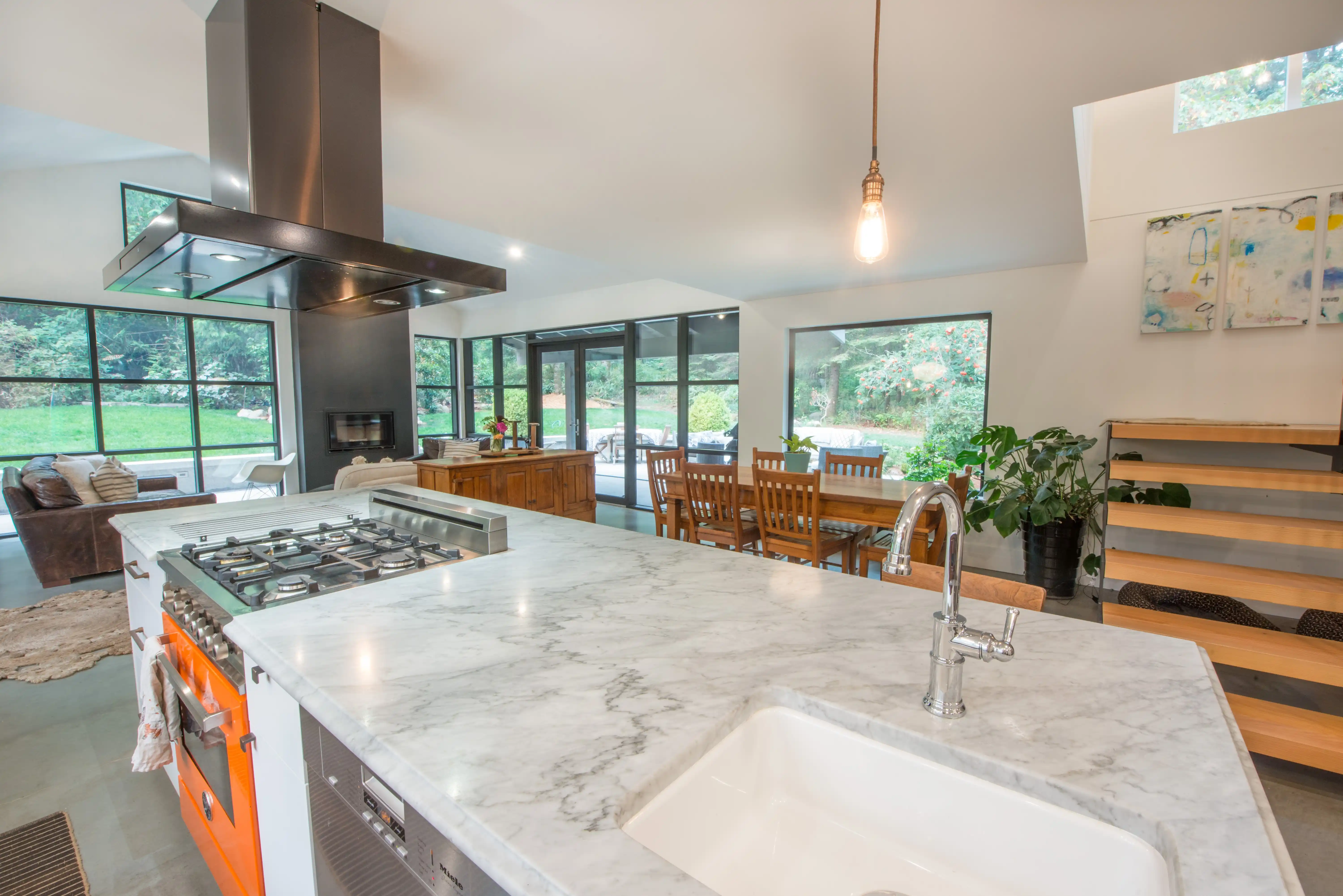 Open-concept kitchen and living area in Garden of Eden with vaulted ceilings and large patio doors to gardens