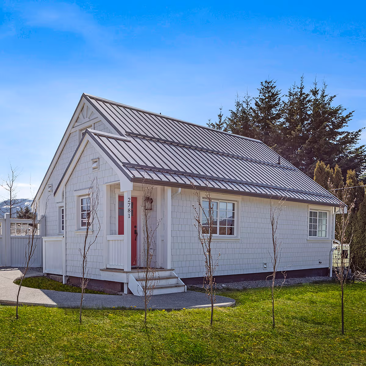 Cumberland Cottage exterior with inviting front porch, decorative gables, and solar metal roof in historic Cumberland BC