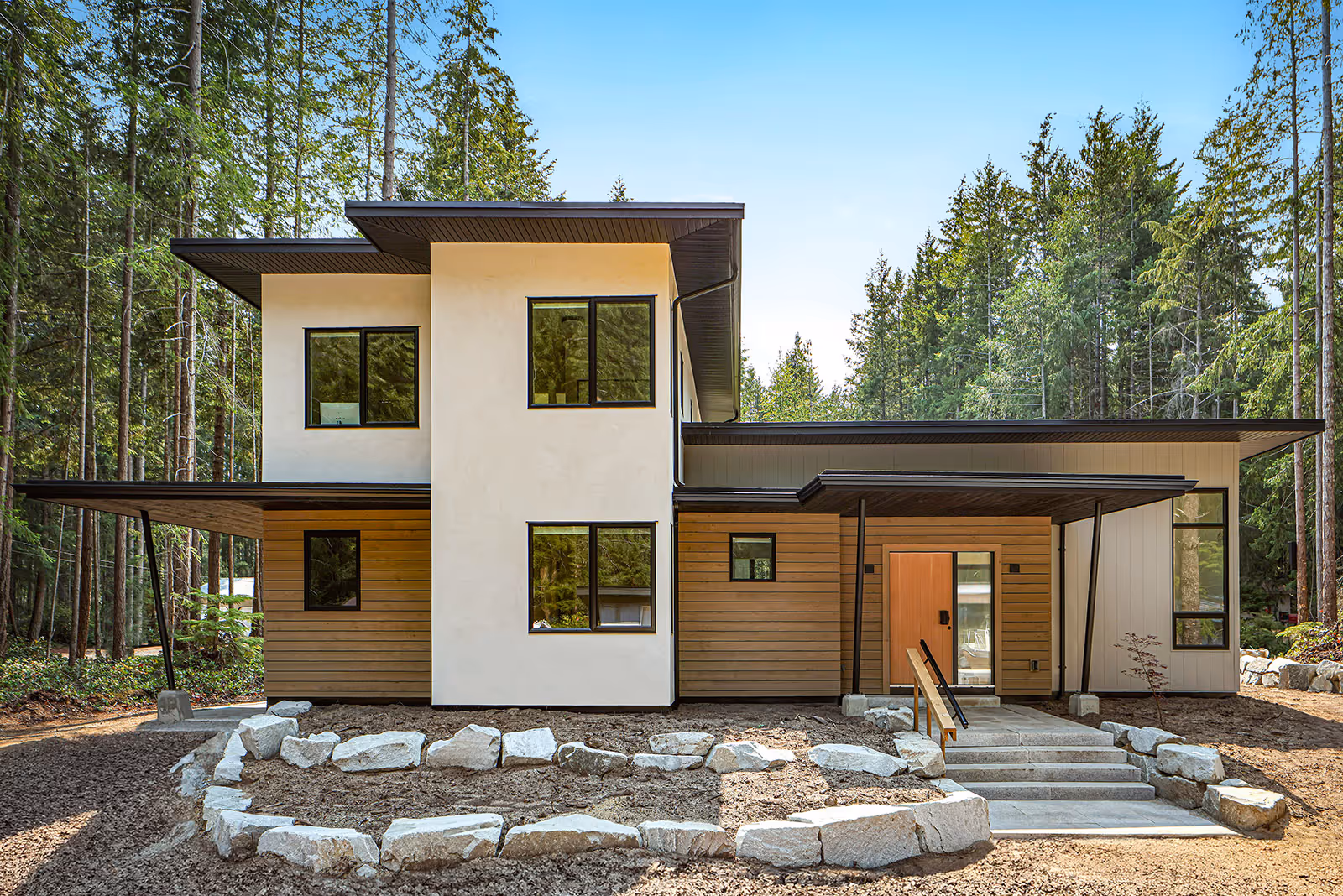 Full exterior view of Pine Forest home with modern west coast architecture and natural wood and siding combination