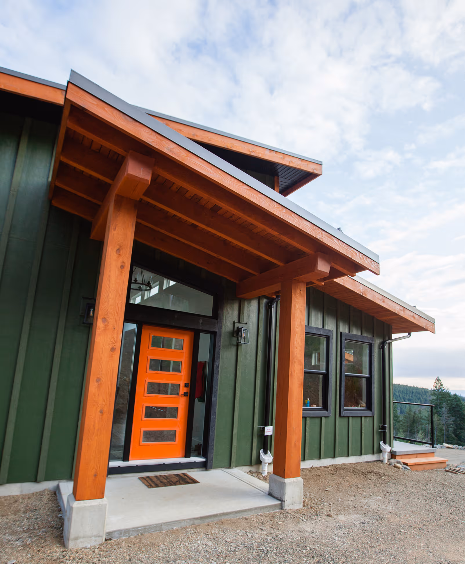 Entrance doorway of The Edge custom home with natural wood framing and mountain setting beyond