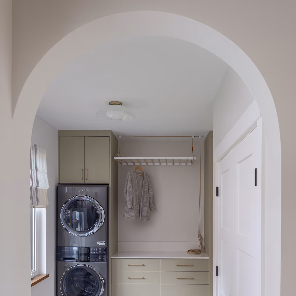 Arched laundry room entrance in The Second Act with custom cabinetry and refined modern details