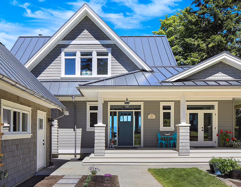 Seabank Cottage oceanfront exterior on Vancouver Island with craftsman grey shingle siding, white trim, and covered porch swings