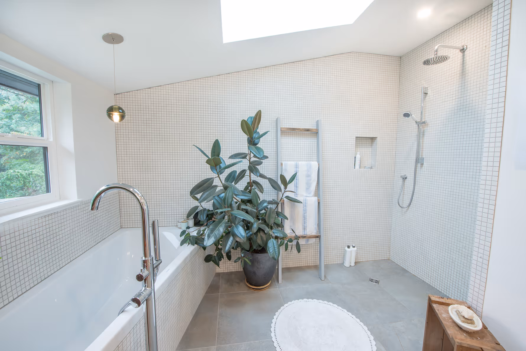 Interior bathroom with large tropical plant in Garden of Eden renovation, featuring hydronic heated tile floors
