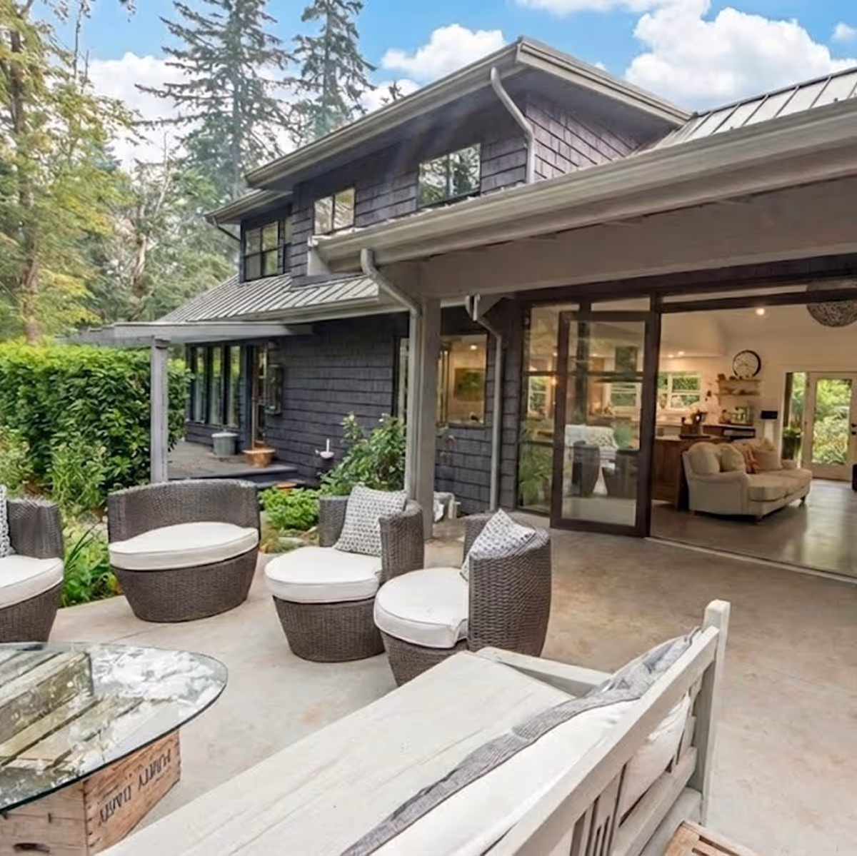 Back exterior of Garden of Eden renovation showing integrated outdoor living and patio set in lush garden setting