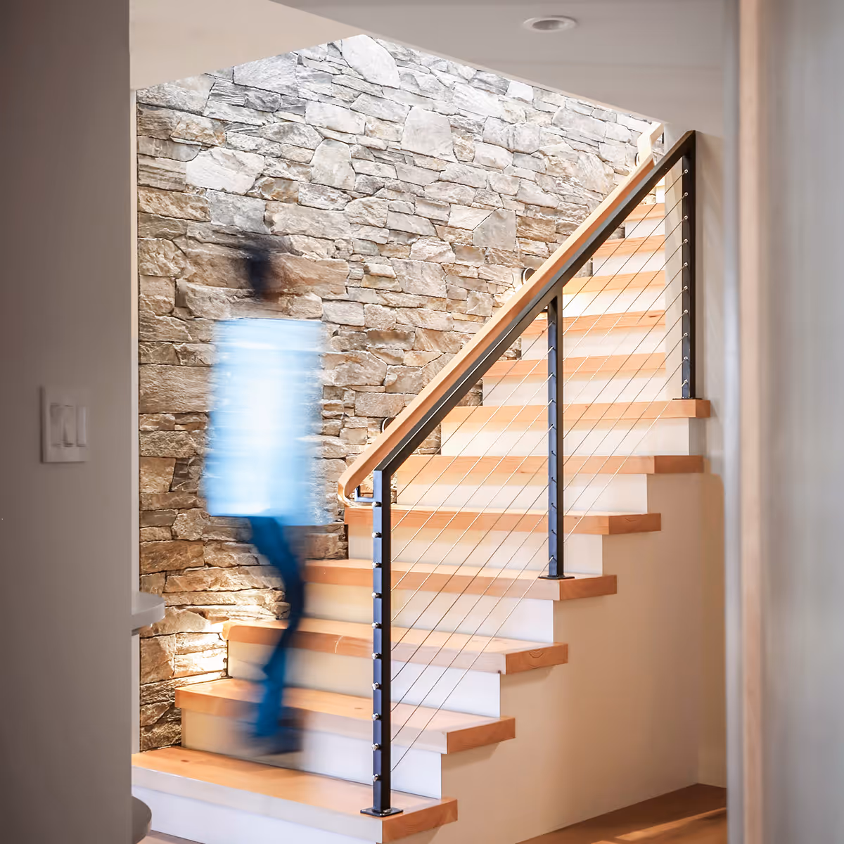 Person ascending staircase in Coastal Point accessible renovation designed for aging in place