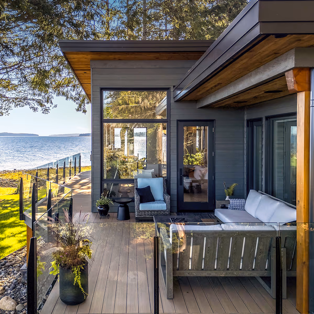 Continuous deck of Coastal Point flowing into riparian-sensitive native landscaping with ocean beyond