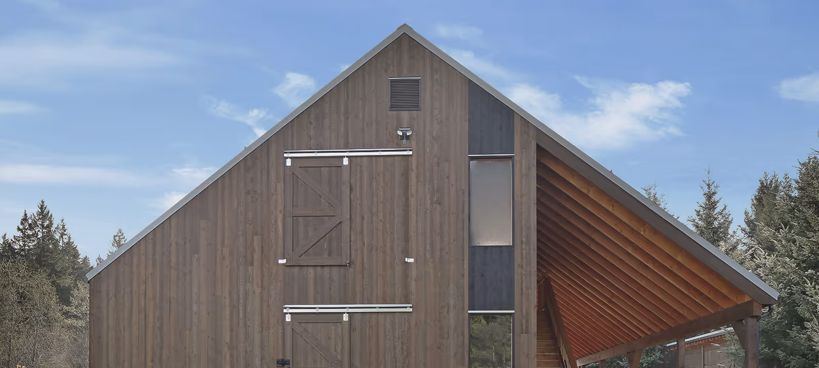Front facade of Sparrow Grass Farm custom barn with monitor-style profile and vertical fir siding in North Courtenay