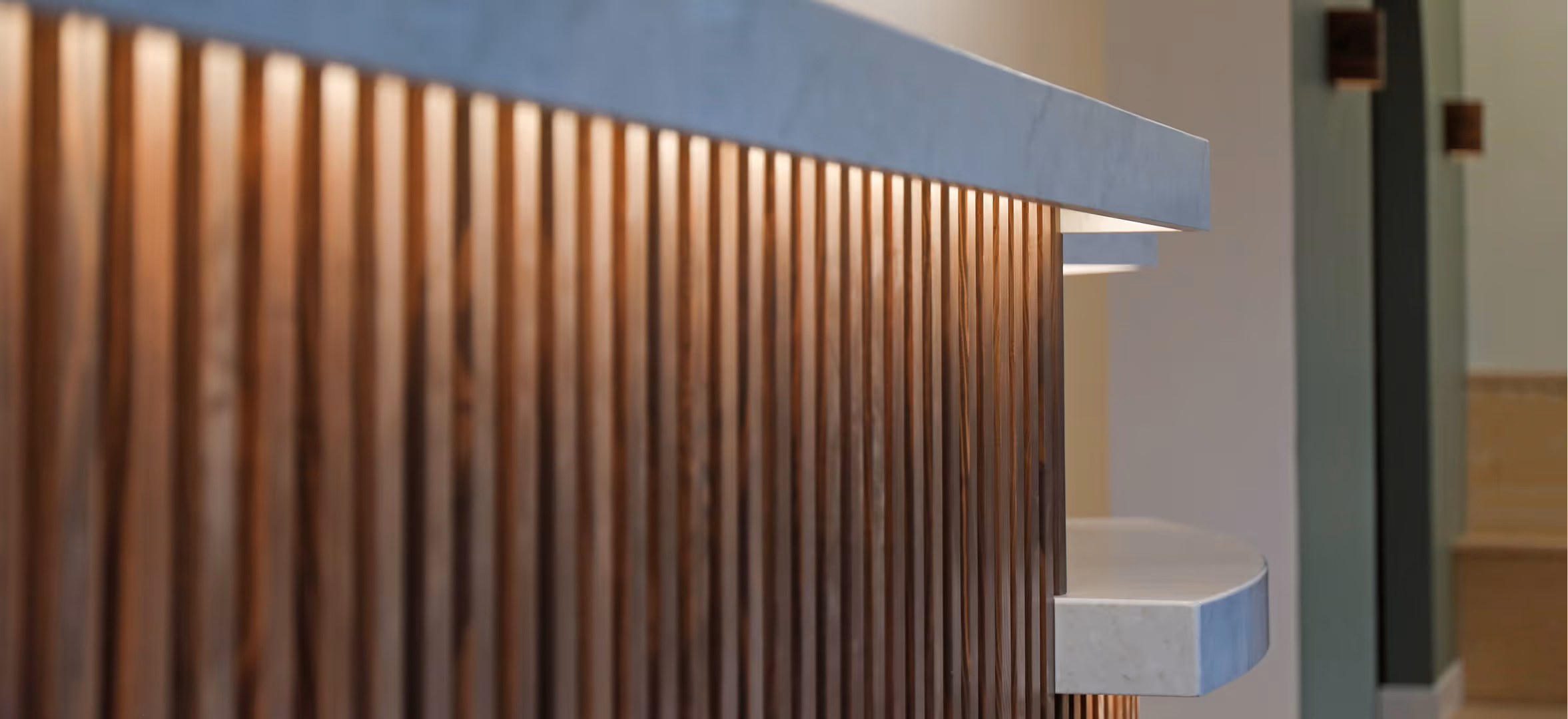 Custom wooden reception desk with vertical wood slat detailing in Westward Medical Clinic