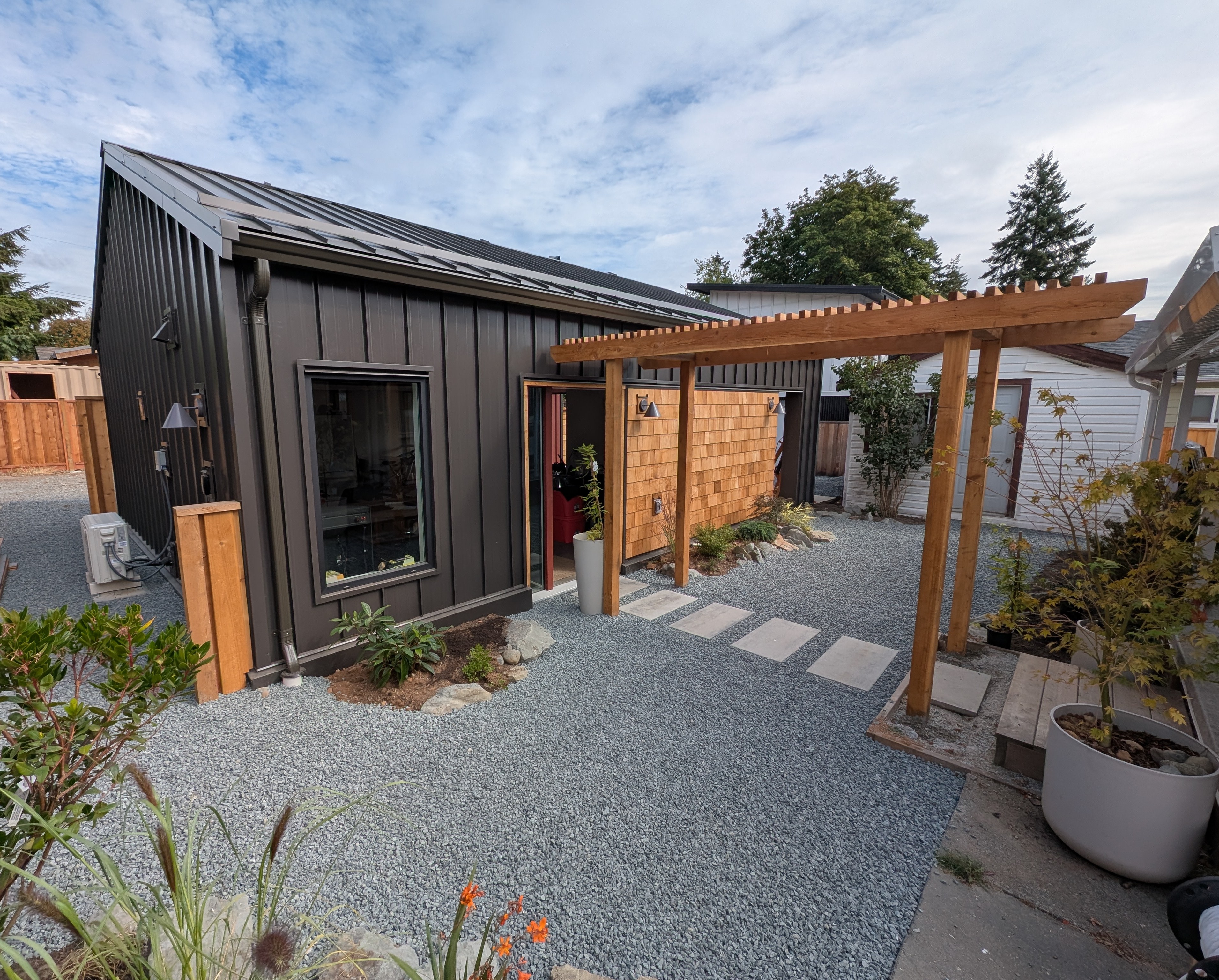 Photo of garage exterior with board and batten siding plus timber awning