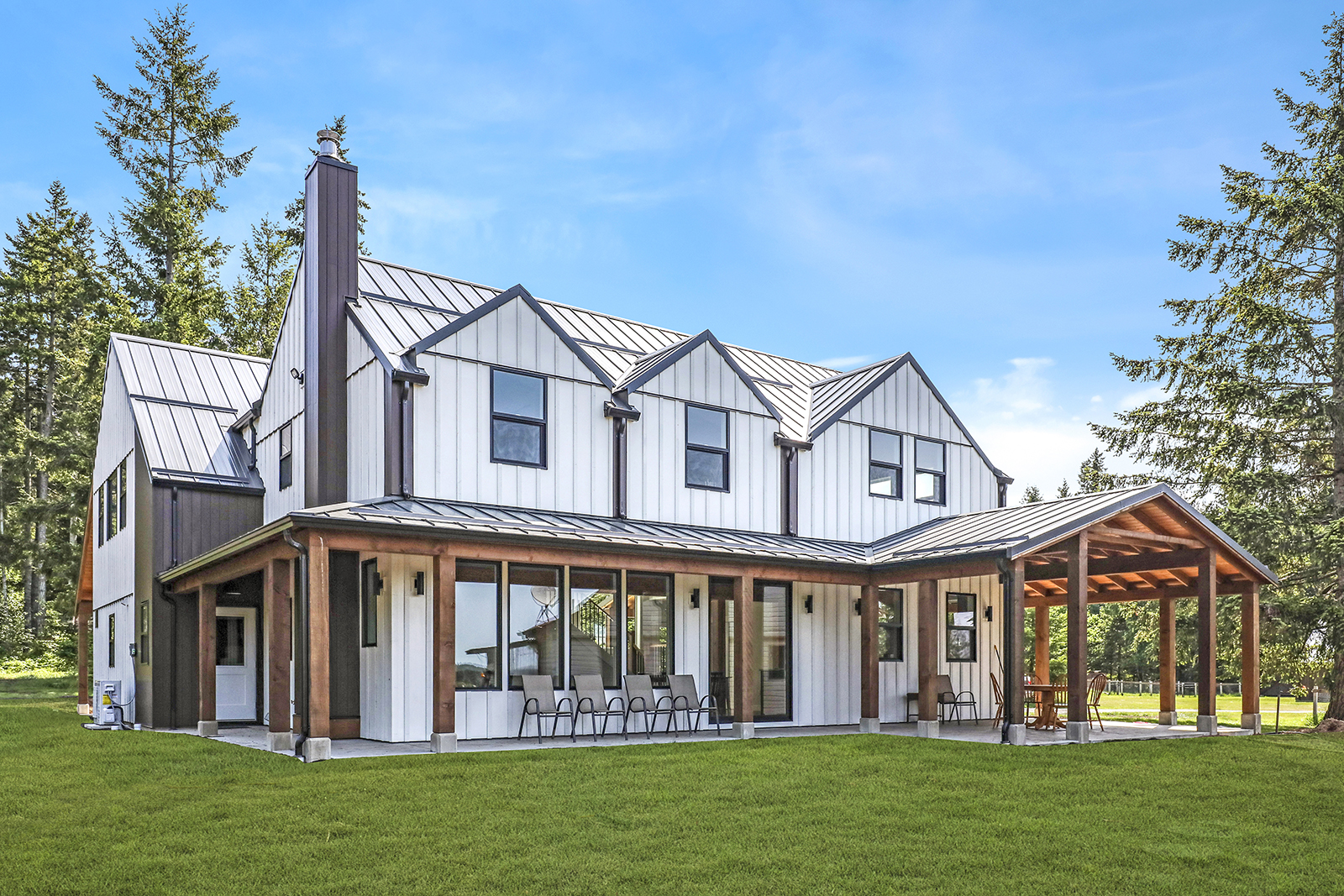 Photo of back exterior of farmhouse showing wrap around deck