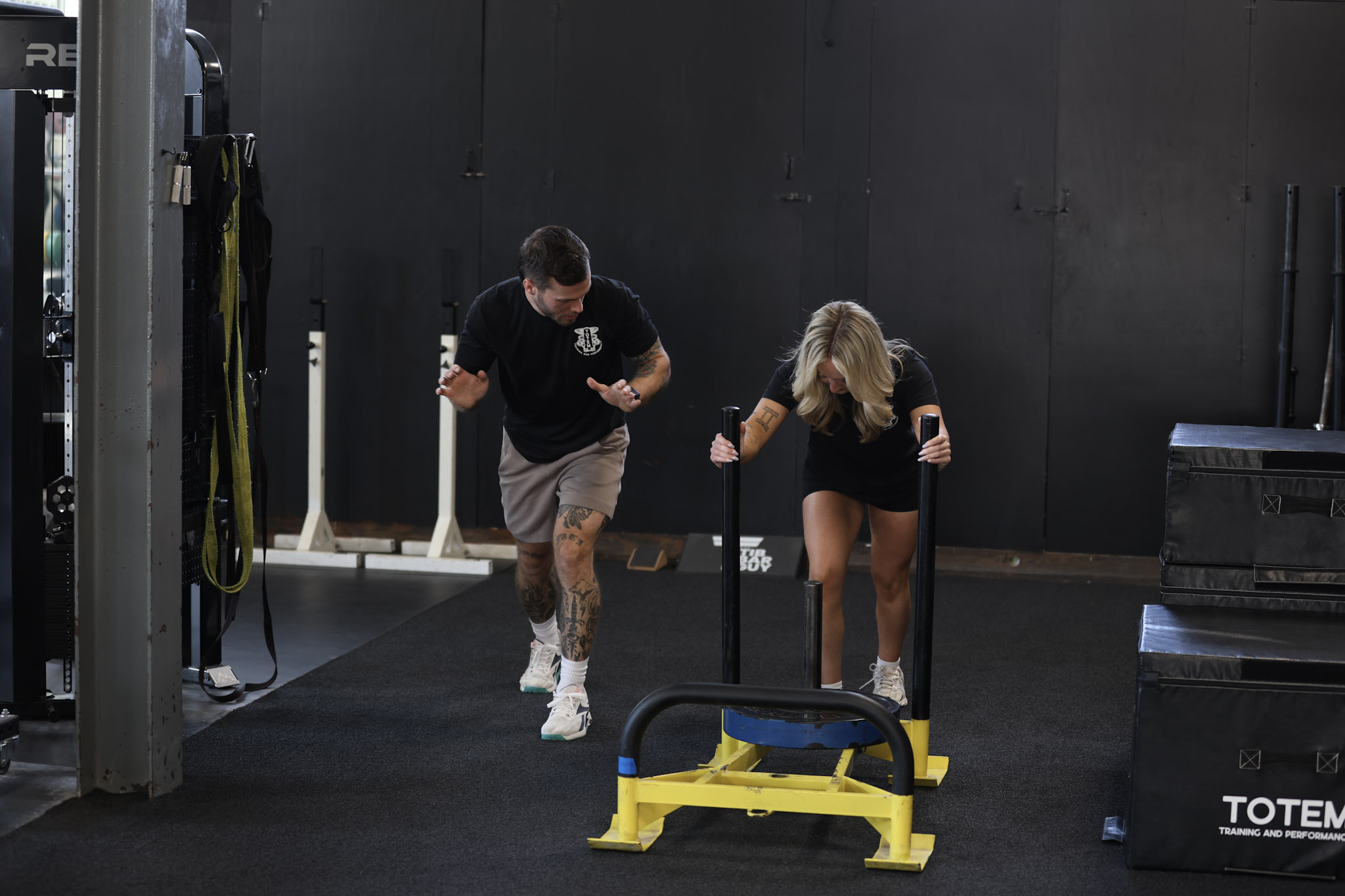 Personal Trainer Instructing Client on Sled Push