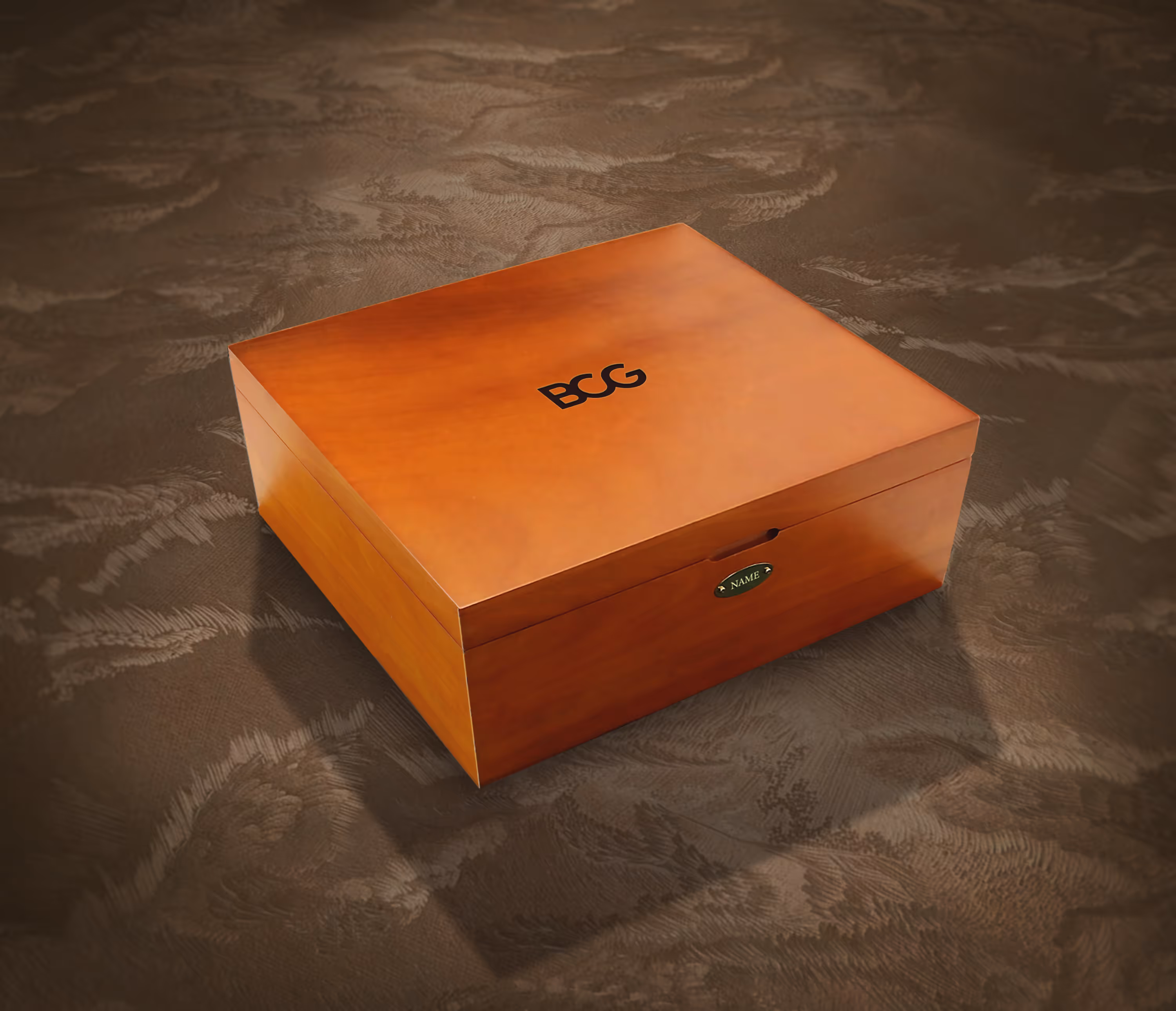 A wood veneered closed BCG wooden box with gold name plaque in an artsy background. 