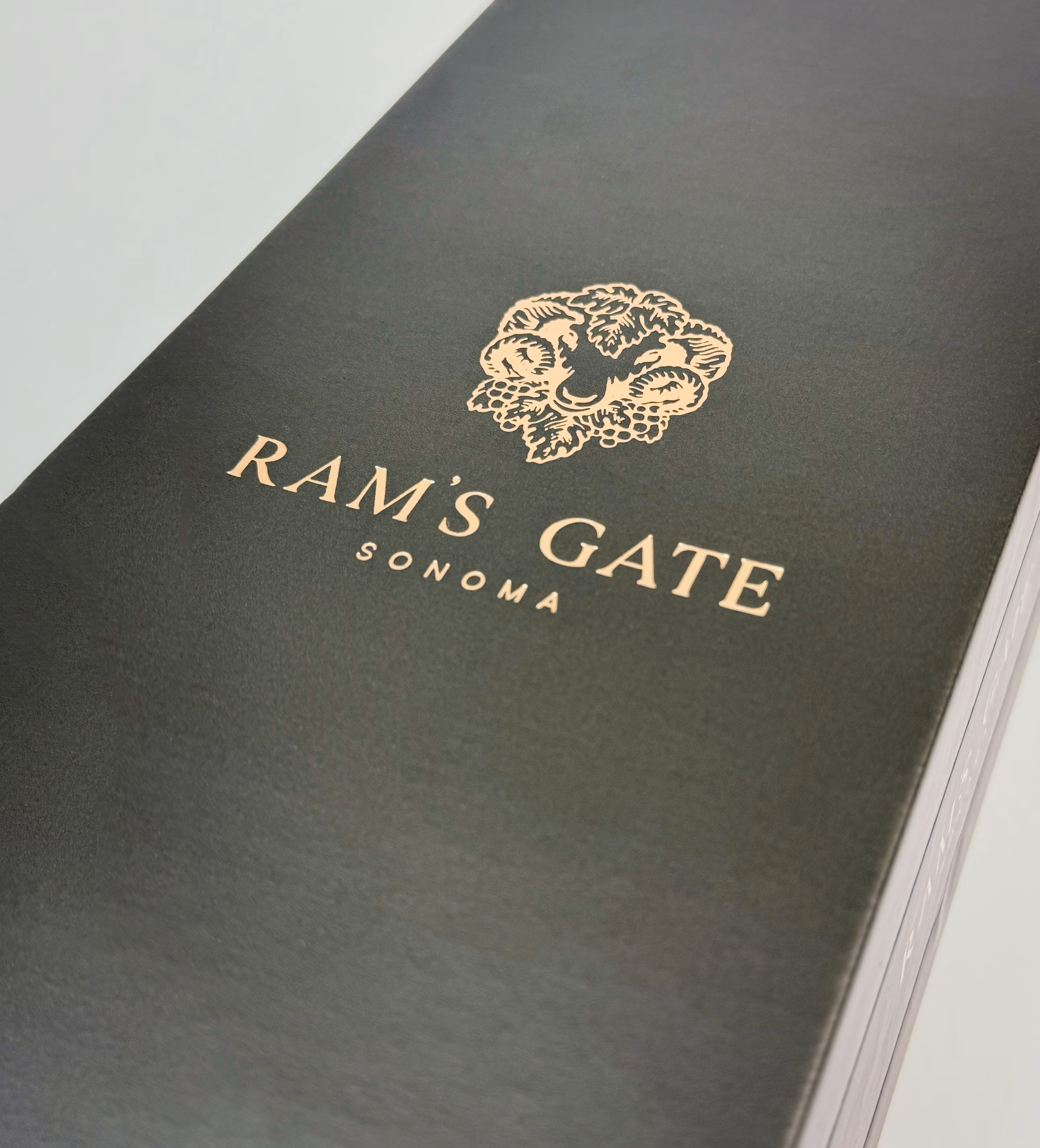 Closeup details of a rose gold foil Ram's Gate logo on the 1-bottle wine box.