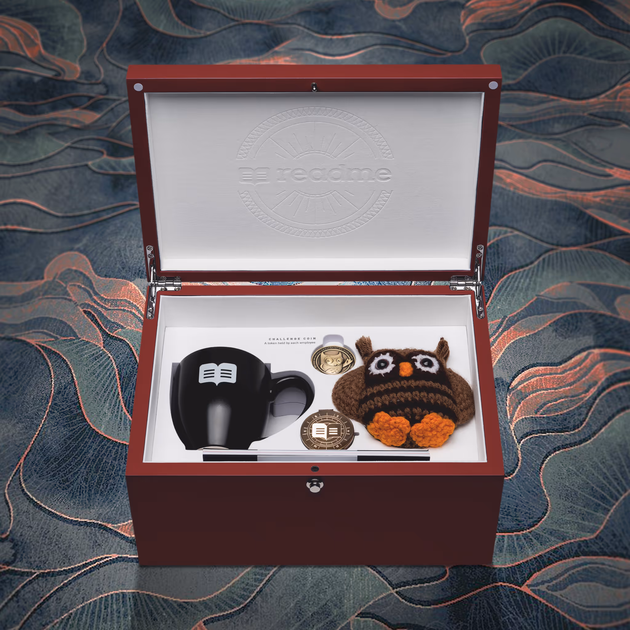 Open wooden Readme new hire box with the brand's plushie, cup, compass and coin in an artsy background.