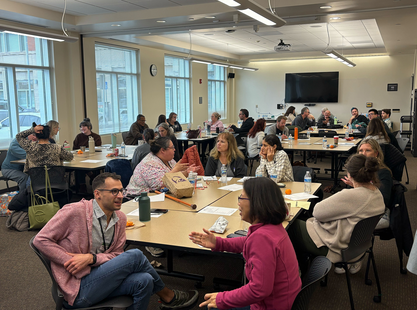 A large group of people engaged in conversation during the Befriending Summit.