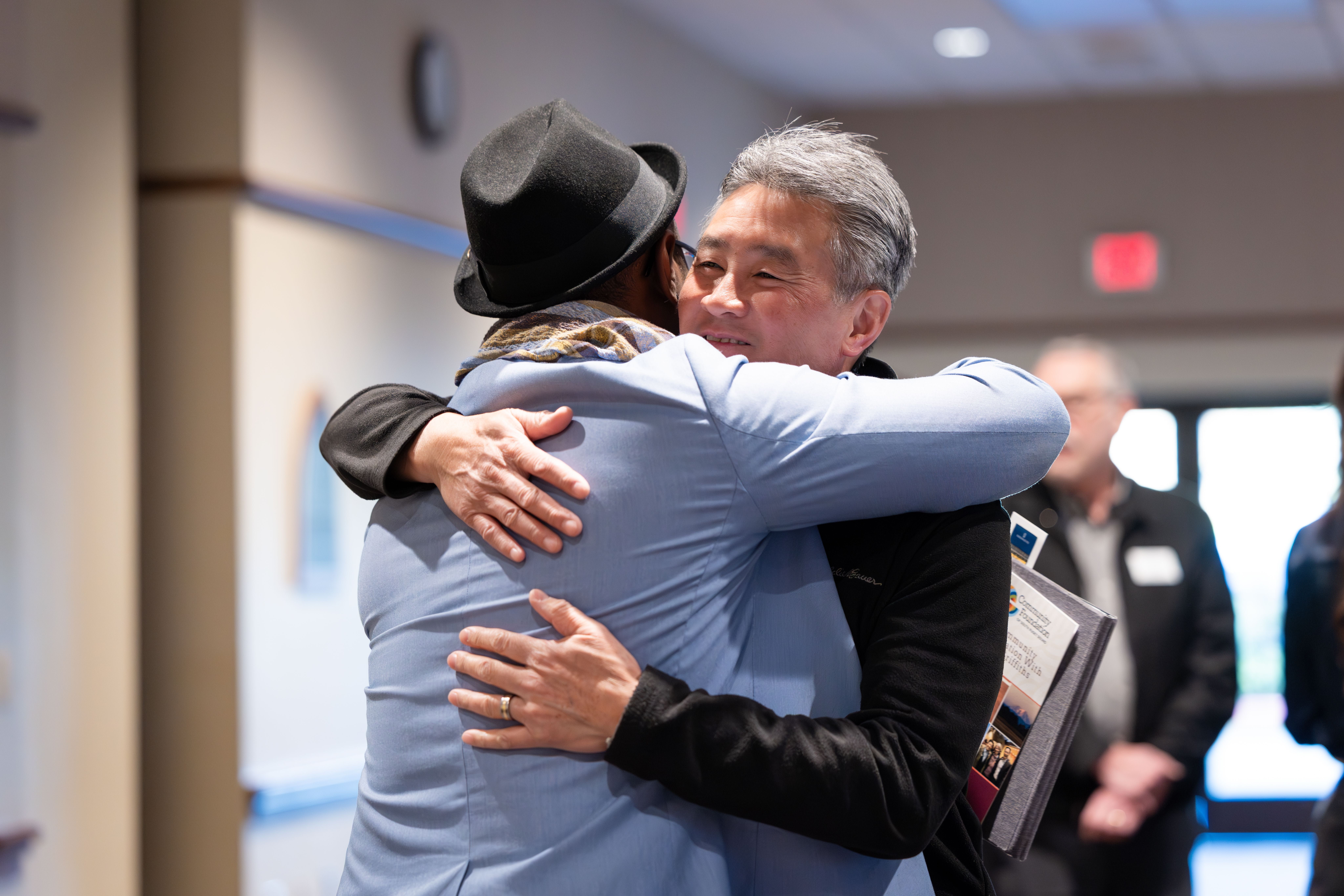 Parfait giving someone a hug at a conference