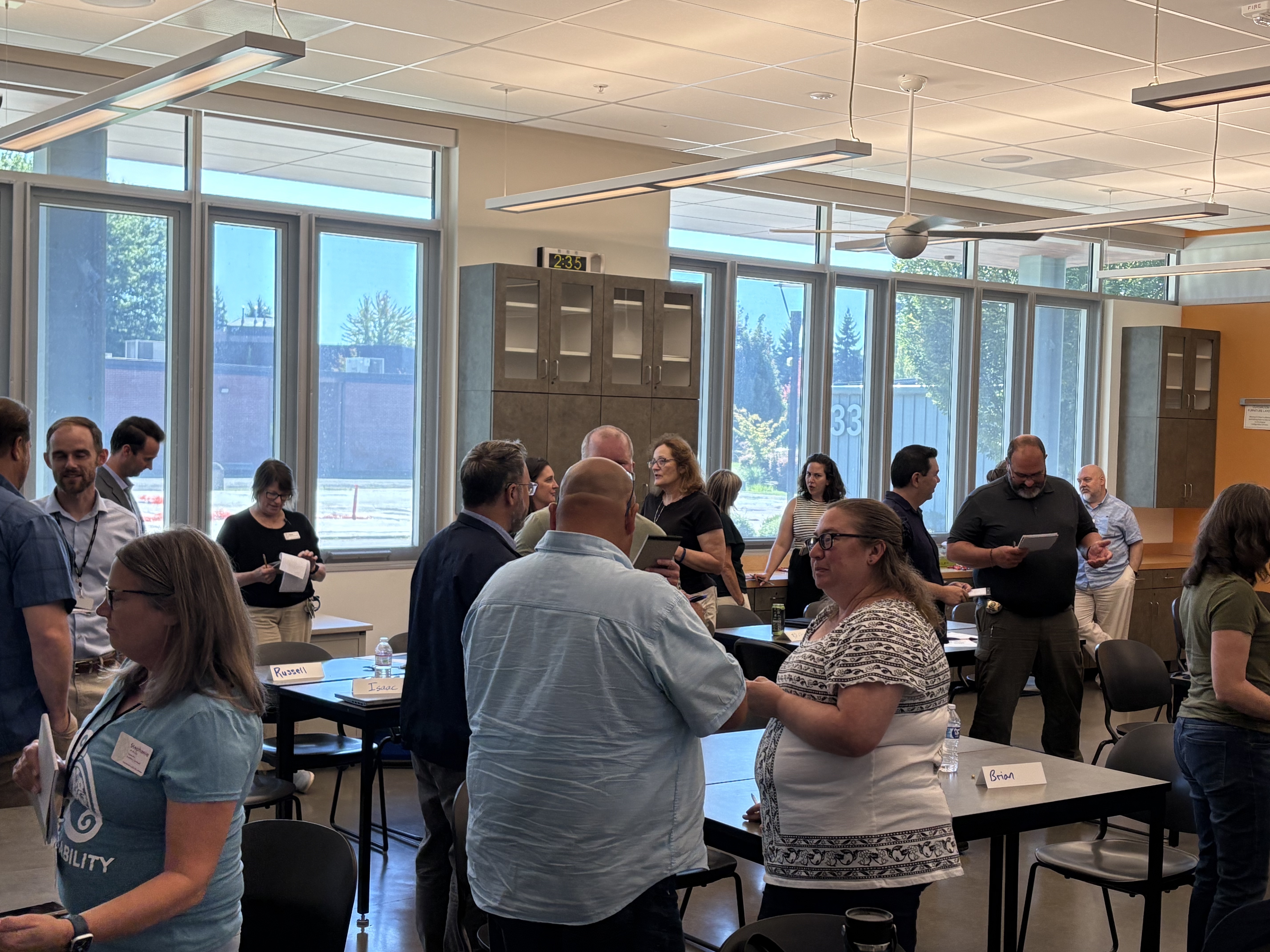 A group of people standing in a room conversing during a summit