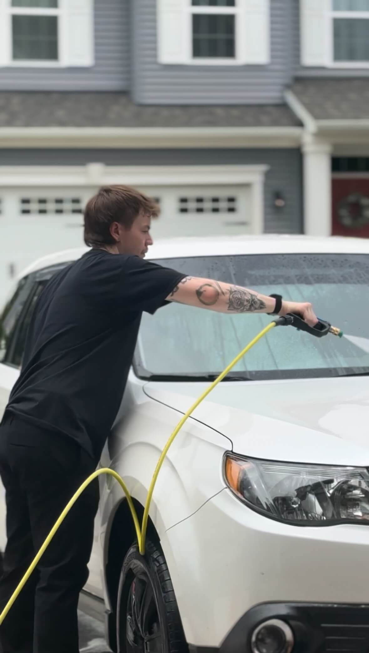 Tristan, owner of Car Detail Near Me 757, detailing a white vehicle in Virginia Beach