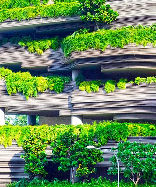A tall building with lush green plants growing on the outside