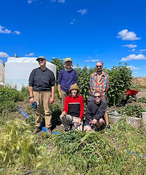 5 personnes souriant dans un champ d'une ferme urbaine
