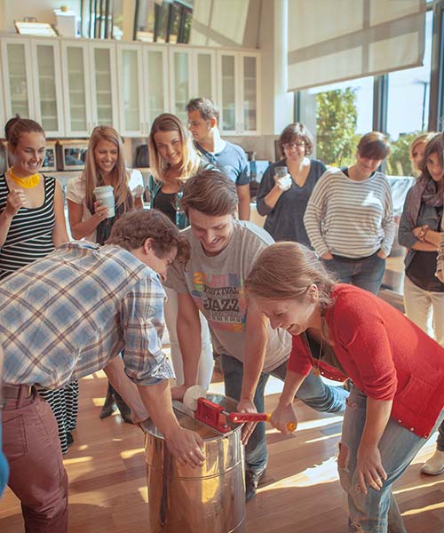 A group of people use a honey extractor. urban biodiversity in real estate