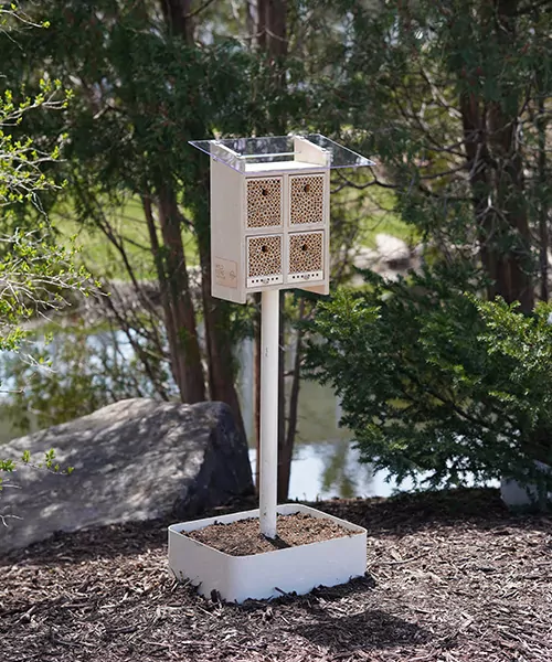 A BeeHome in front of some trees. how to support wild bees
