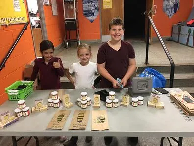 Twin Oaks school students in front of their personalized honey jars from their beehives.