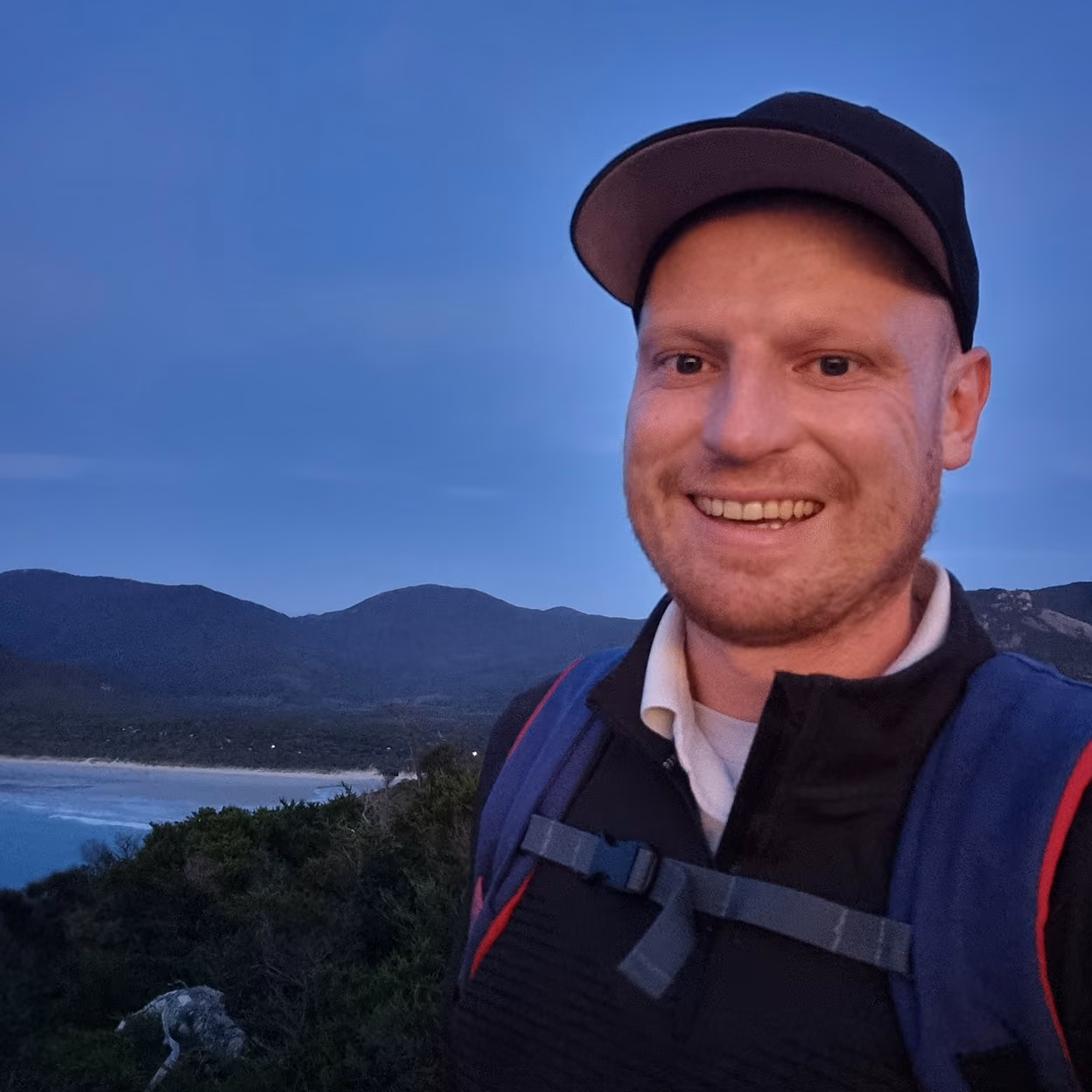 Jake Harris with a mountain in the background showing how he helps people break through their upperlimit with business and mindset coaching.