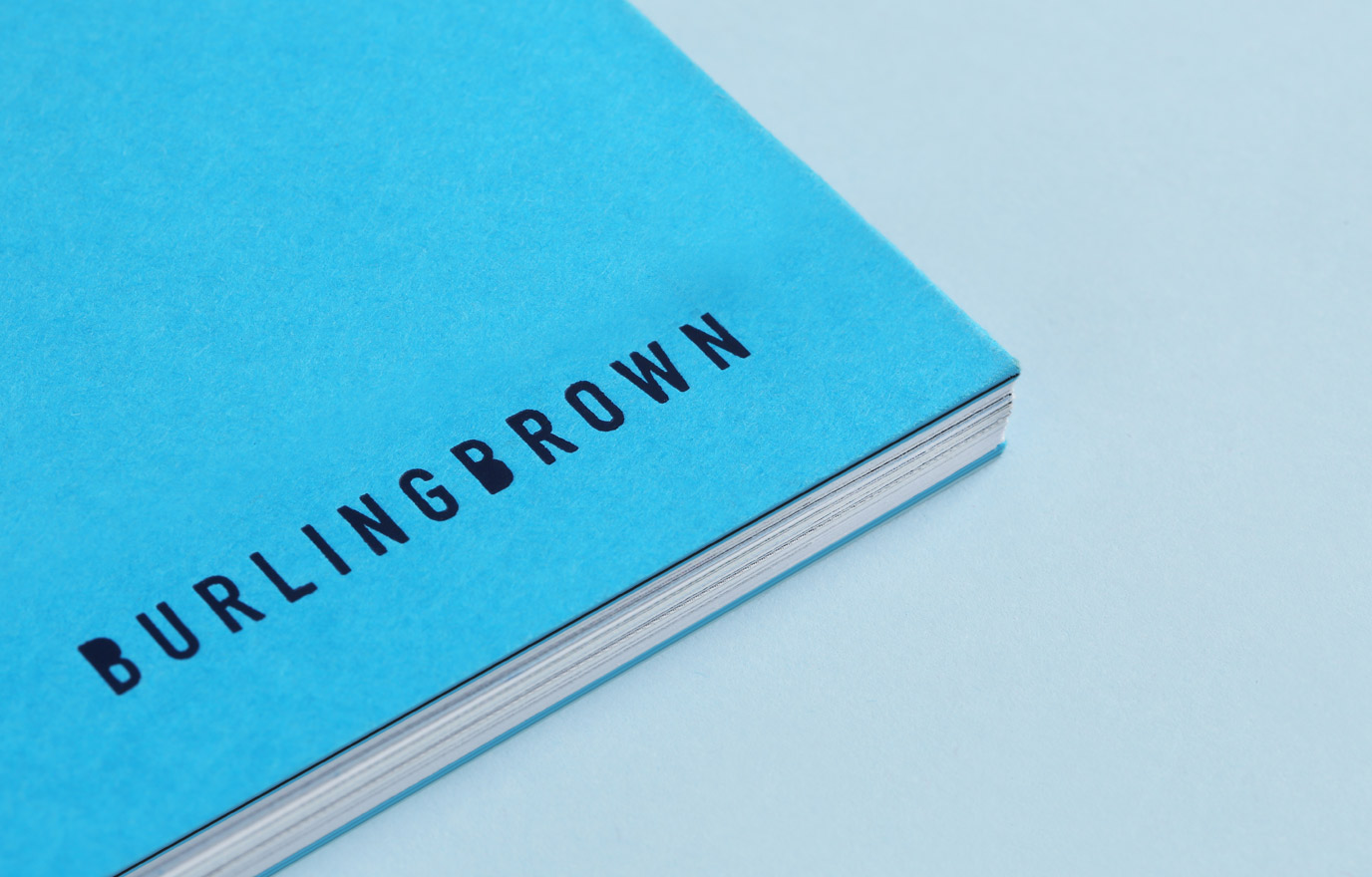 Burling Brown Brand image. Close-up of a blue book cover with the word 'BURLINGBROWN' printed in black letters.
