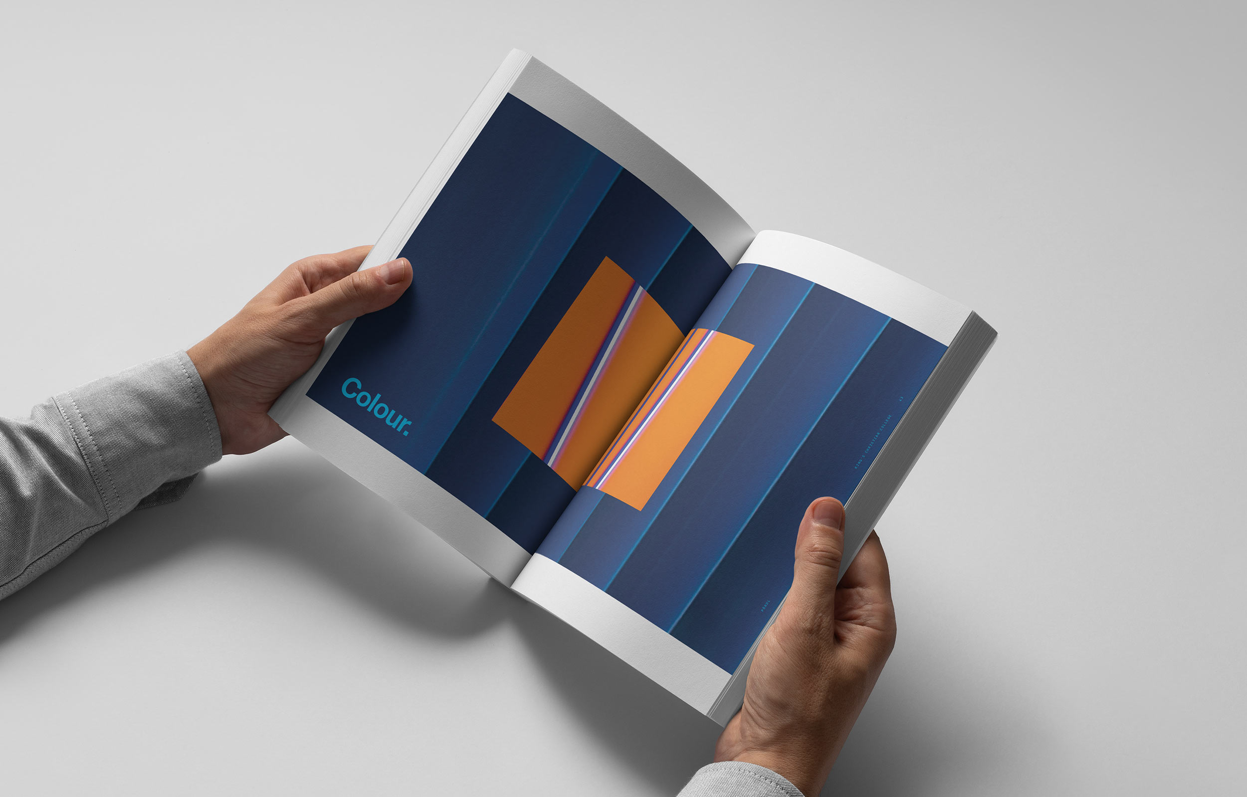 Burling Brown Brand image. Two hands holding an open book showing blue pages with orange shapes and the word 'Colour' on the left page.
