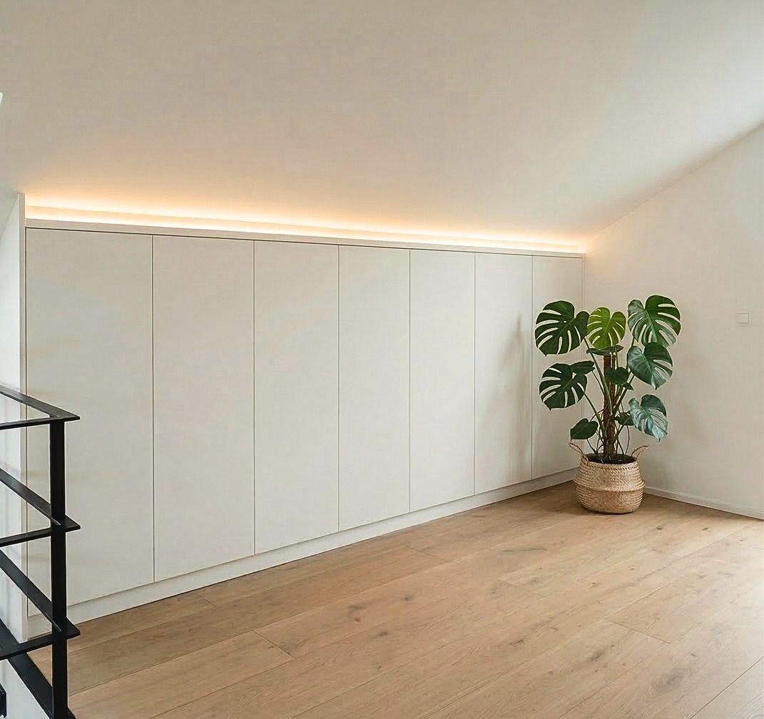 Raumhoher Einbauschrank in Weiß mit indirekter LED-Beleuchtung an der Dachschräge – Schreinerei Hergert Mannheim