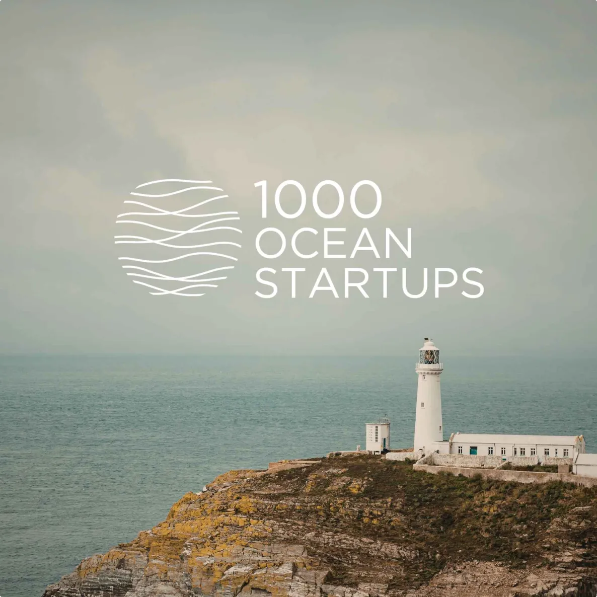 White lighthouse on rocky coastline with calm ocean and cloudy sky, overlaid with 1000 Ocean Startups logo.