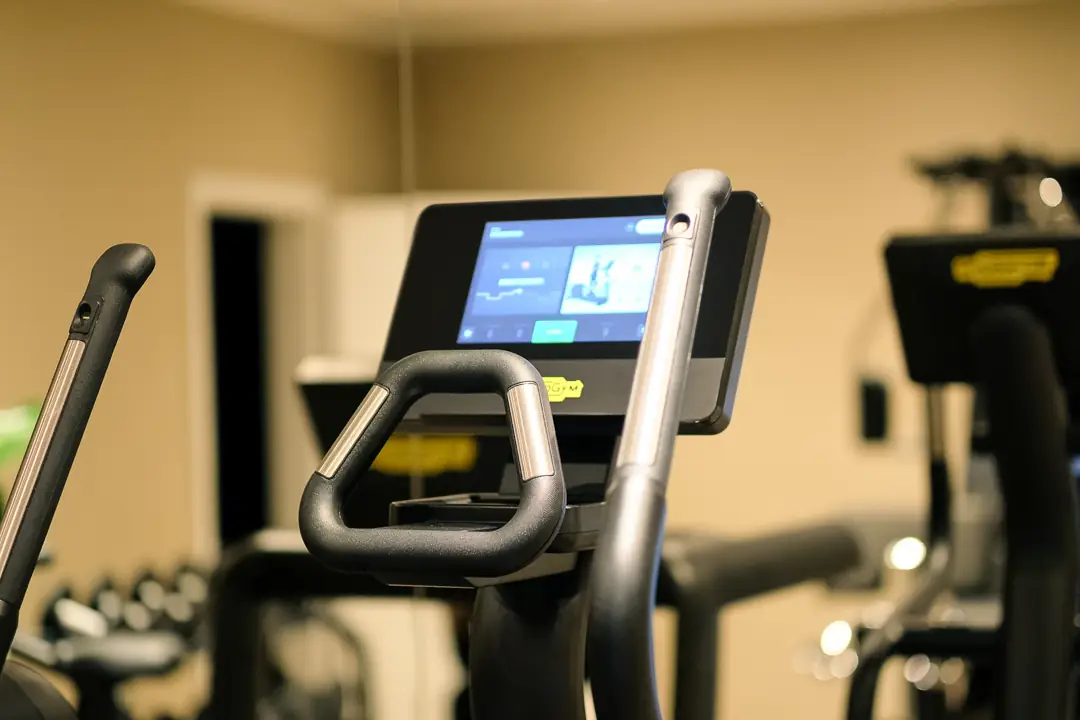 Nahaufnahme eines Fitnessgeräts mit digitalem Bildschirm in einem Fitnessstudio.