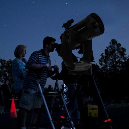 a couple looking through a celestron telescope