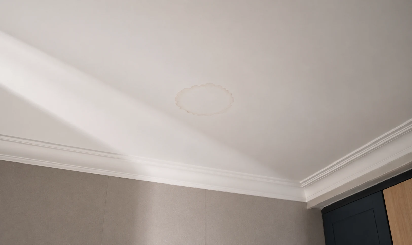 Auréole d'une ancienne fuite, restée visible au plafond d'une chambre
