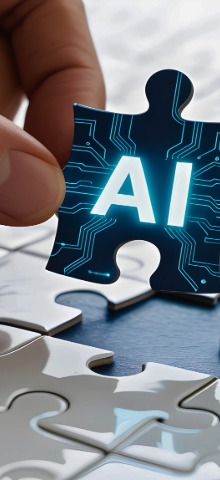 Hand holding a puzzle piece with AI and circuit board design over a white puzzle board.