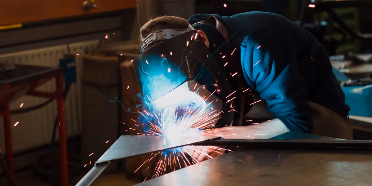 Welder bending with sparks flying