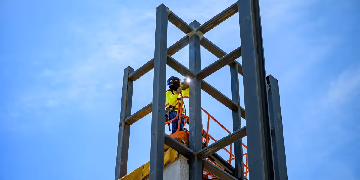 Welder on lift working on tall metal project