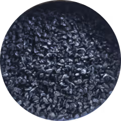 Close-up of coarse black granular material, possibly crushed carbon or charcoal particles.