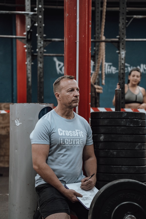 a man sitting on a bench in a crossfit gym