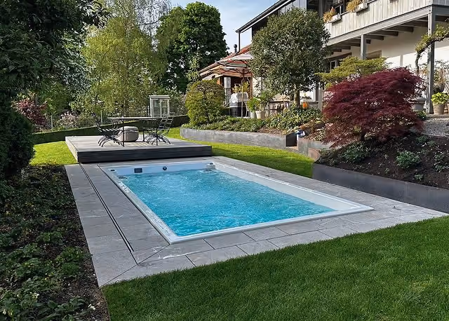 Moderner Pool mit motorisierter grauer Abdeckung im Garten