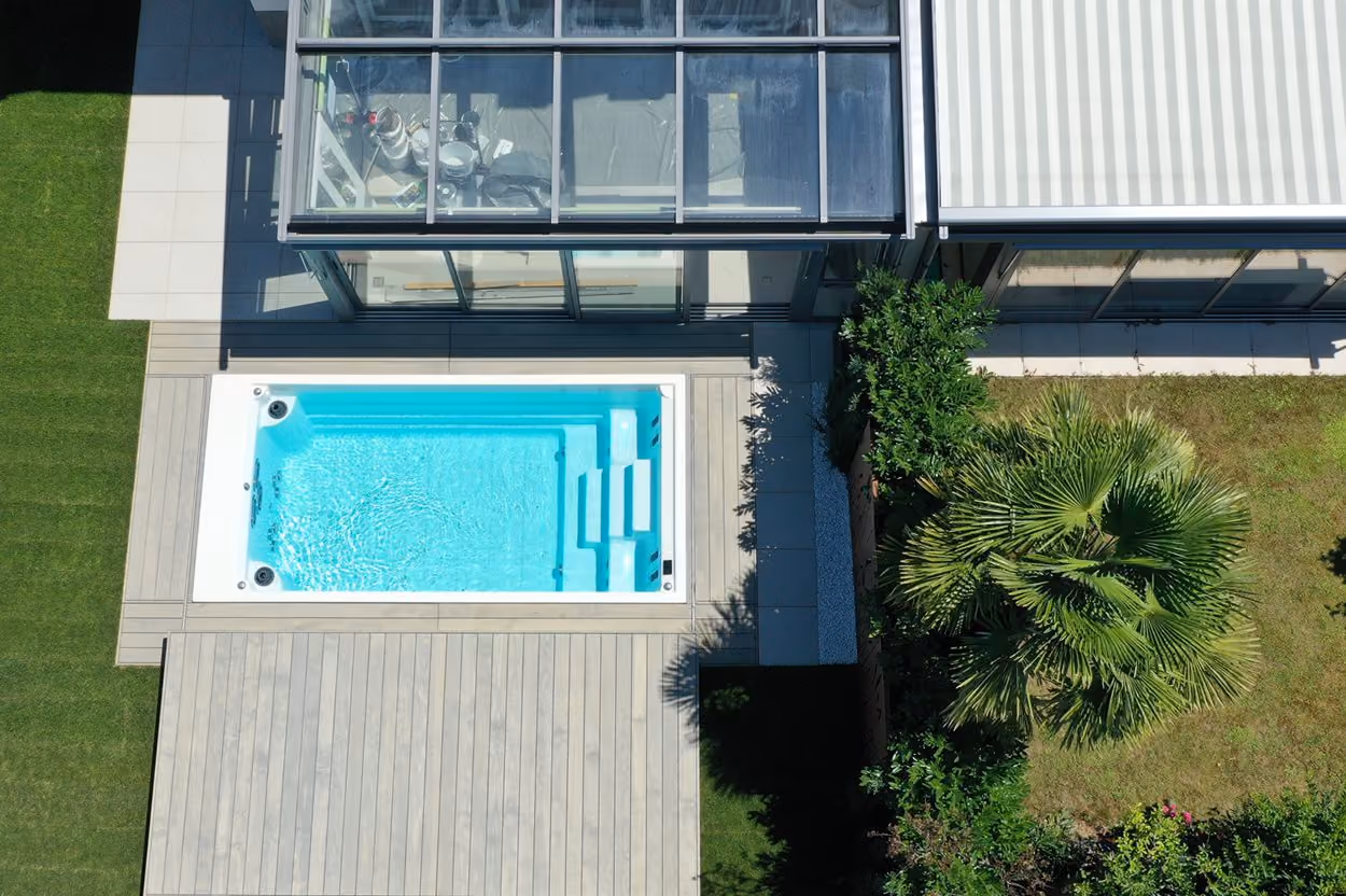 Moderner rechteckiger Pool mit heller Abdeckung aus Luftaufnahme