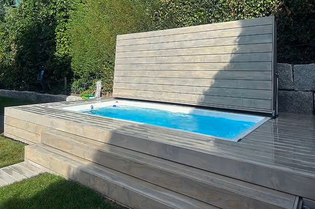 Moderner Swim Spa mit Holzabdeckung in angelegtem Gartensetting