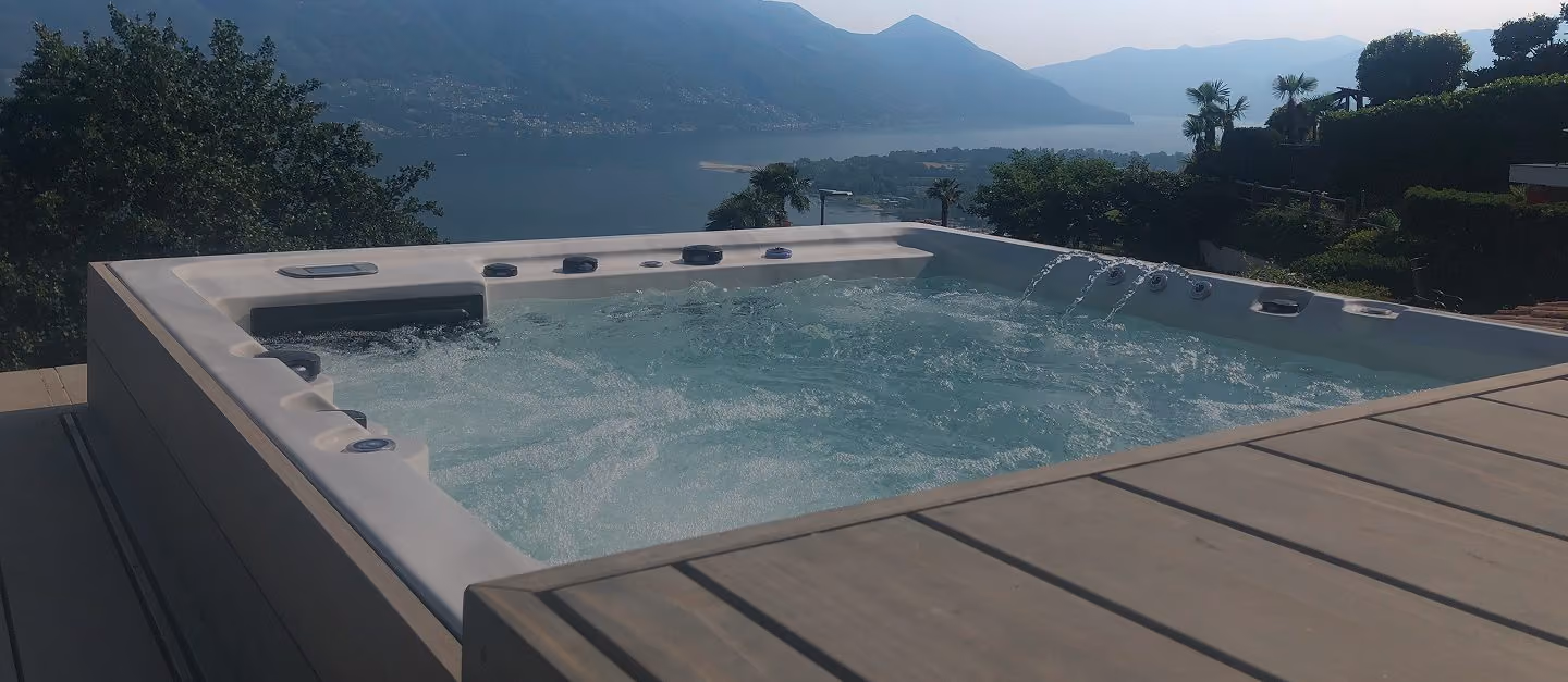 Premium-Whirlpool mit Seelandschaft und Bergketten im Hintergrund