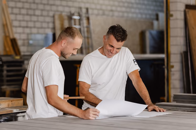 Zwei Mitarbeiter von RR Variationen besprechen einen Wellness-Grundriss.
